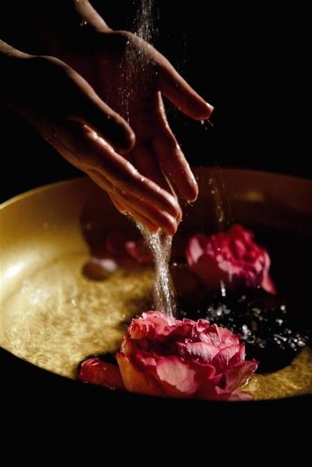 Hands in a ceremonial bowl of roses